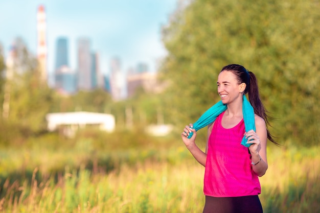 Młoda uśmiechnięta kobieta robi sporty ćwiczeniom outdoors