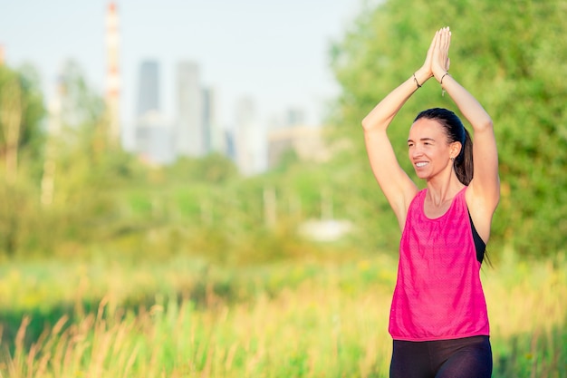 Młoda uśmiechnięta kobieta robi sporty ćwiczy outdoors