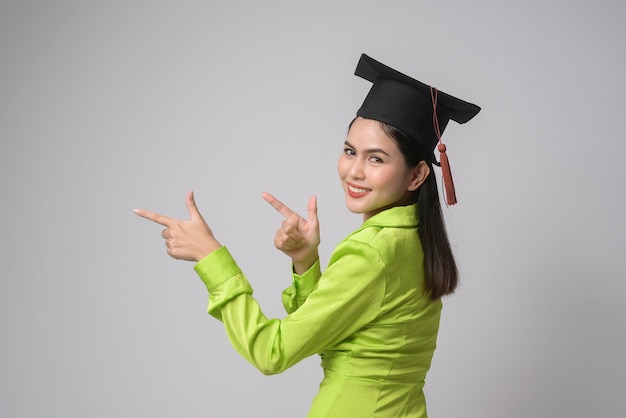 Młoda uśmiechnięta kobieta w kapeluszu ukończenia szkoły, koncepcja edukacji i uniwersytetux9