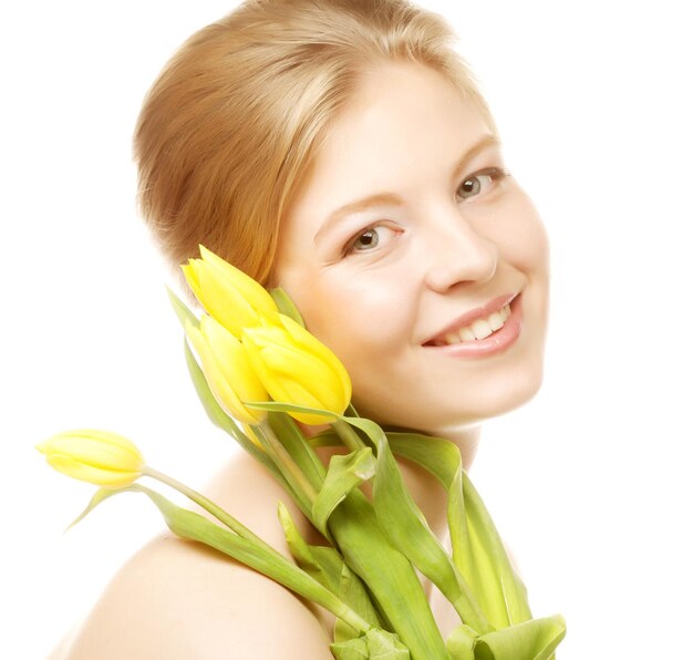 Młoda uśmiechnięta kobieta z żółtymi tulipanami