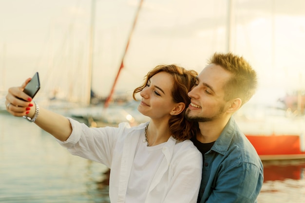 Młoda uśmiechnięta para w miłości robi selfie portretowi z telefonem. Romantyczna koncepcja
