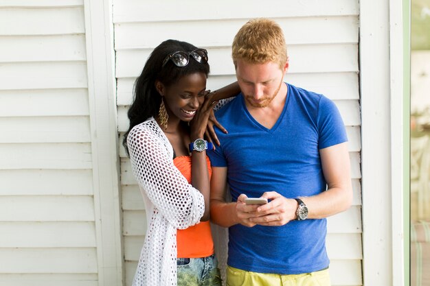 Młoda wieloetniczna para z smartphone przy latem