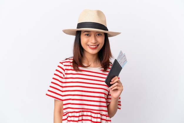 Młoda Wietnamka na białym tle szczęśliwa na wakacjach z paszportem i biletami lotniczymi