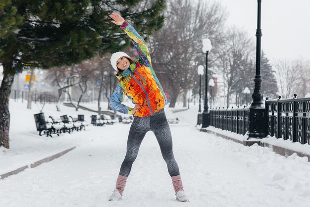 Młoda wysportowana kobieta uprawia sport w mroźny i śnieżny dzień. Fitness, bieganie