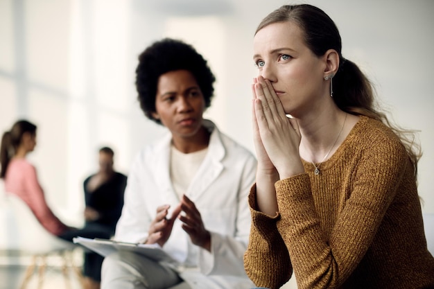 Młoda zrozpaczona kobieta umawiająca się na wizytę u psychoterapeuty