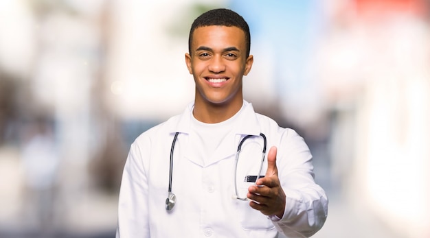 Młode afro amerykańskie mężczyzna lekarki chwiania ręki dla zamykać dobrą transakcję przy outdoors