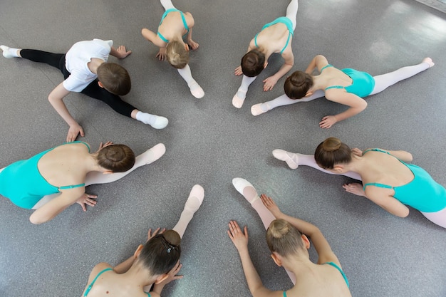 Młode Baleriny Wykonują Różne ćwiczenia Choreograficzne Siedząc Na Podłodze
