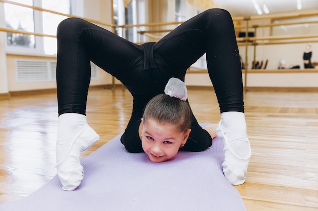 Młode dziewczyny robiące ćwiczenia gimnastyczne lub ćwiczące na zajęciach fitness