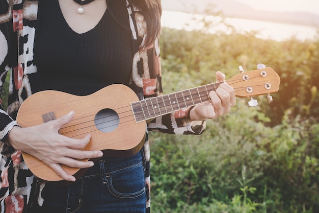 Zdjęcie młode kobiety bawić się na ukulele