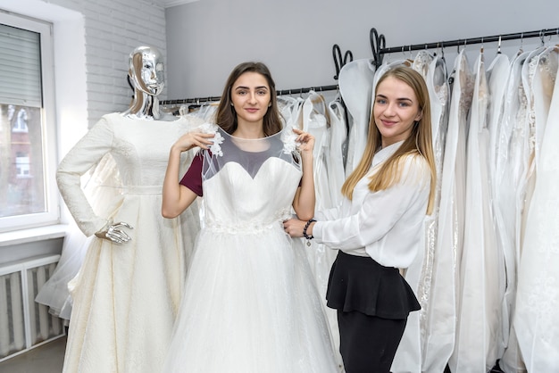 Młode kobiety w salonie ślubnym, wybierając sukienkę