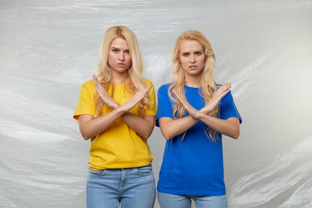 Zdjęcie młode kobiety zgłaszają się na ochotnika w żółtych i niebieskich koszulkach przeciwko polietylenowi i plastikowi. koncepcja recyklingu odpadów