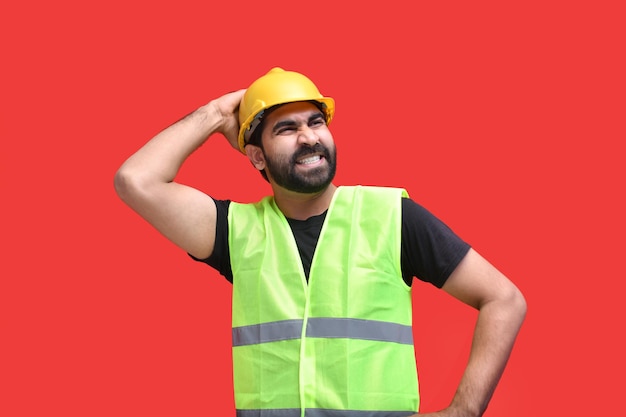młode myślenie budowlane z rękami na głowie na czerwonym tle indyjski model pakistański