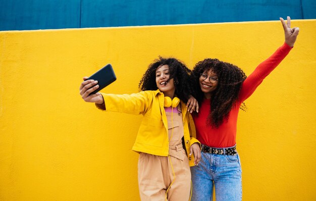 Młode szczęśliwe kobiety robiące selfie smartfonem