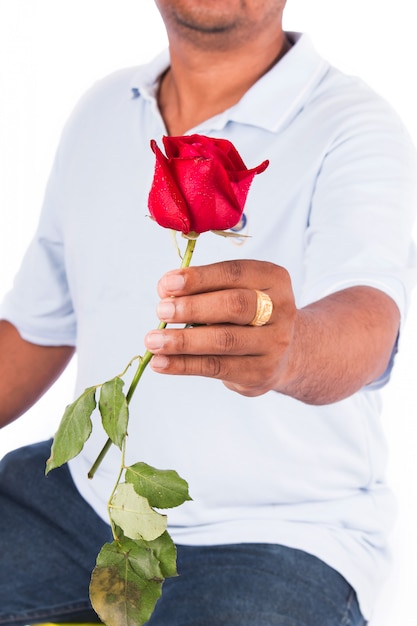Młodego człowieka chwyta róży kwiat