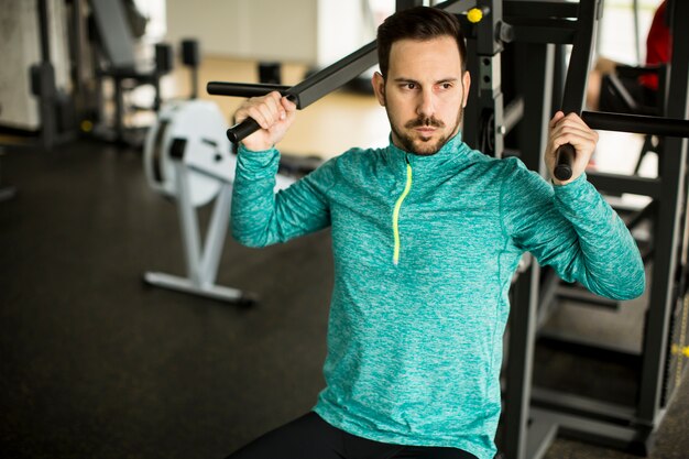 Młodego człowieka ćwiczenie na ćwiczenie maszynie przy gym