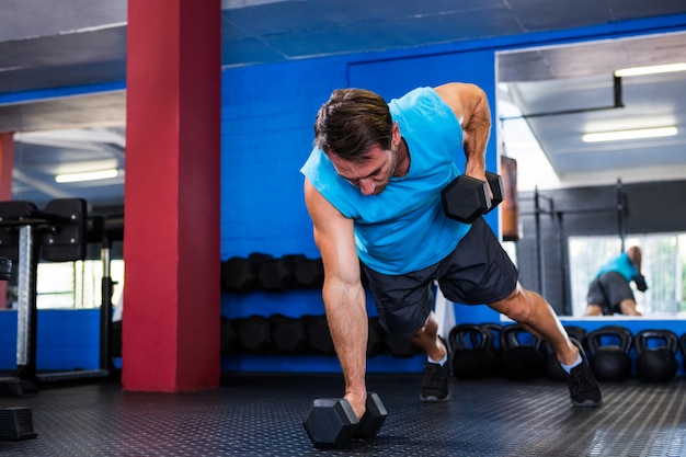 Młodej atlety podnośni dumbbells w gym