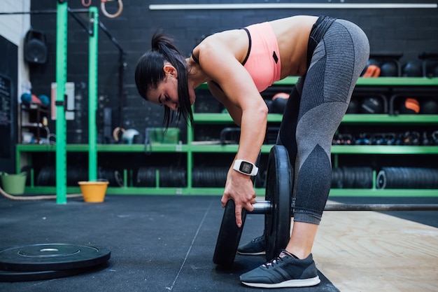 Młodej kobiety narządzania dumbbell stażowy gym