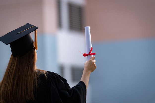 Zdjęcie młody absolwent uczelni posiada dyplom ukończenia studiów