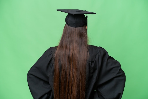 Młody absolwent uniwersytetu Azjatycka kobieta nad odizolowanym tłem w tylnej pozycji