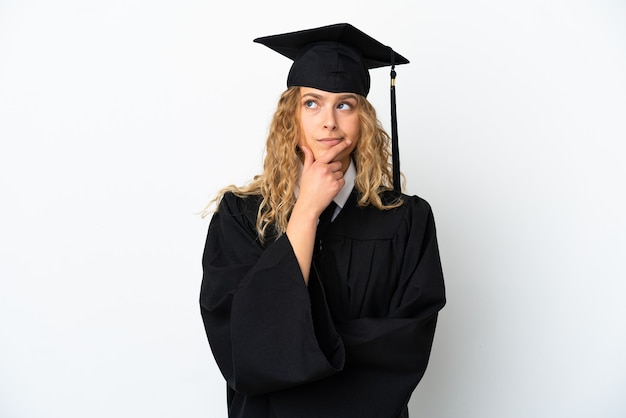 Zdjęcie młody absolwent uniwersytetu na białym tle mający wątpliwości