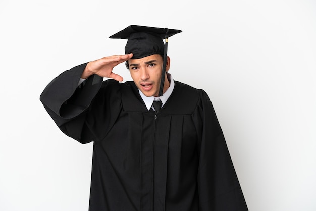 Młody absolwent uniwersytetu nad odosobnionym białym tłem, patrząc daleko ręką, aby coś wyglądać