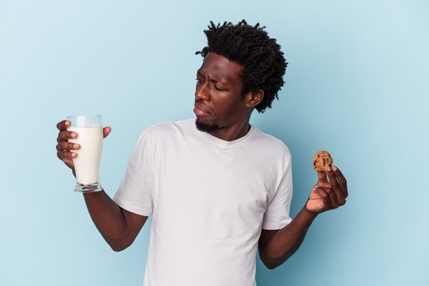 Młody Afroamerykanin Je Ciasteczka Z Kawałkami Czekolady I Pije Mleko Na Niebiesko