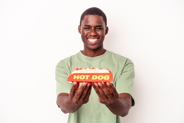 Młody Afroamerykanin je hot doga na białym tle