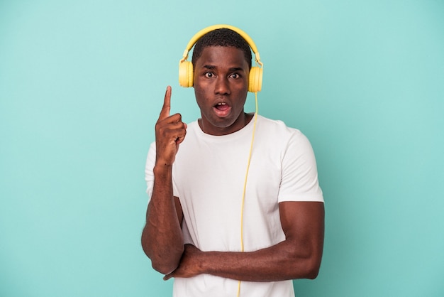 Młody Afroamerykanin Słuchanie Muzyki Na Białym Tle Na Niebieskim Tle O Jakiś świetny Pomysł, Pojęcie Kreatywności.