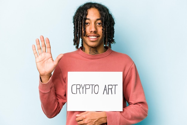Młody Afroamerykanin trzymający afisz sztuki kryptograficznej na białym tle na niebieskim tle, uśmiechający się wesoło pokazując cyfrę pięć palcami
