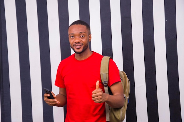 Młody afrykański student czuje się podekscytowany, gdy obsługuje swój telefon komórkowy