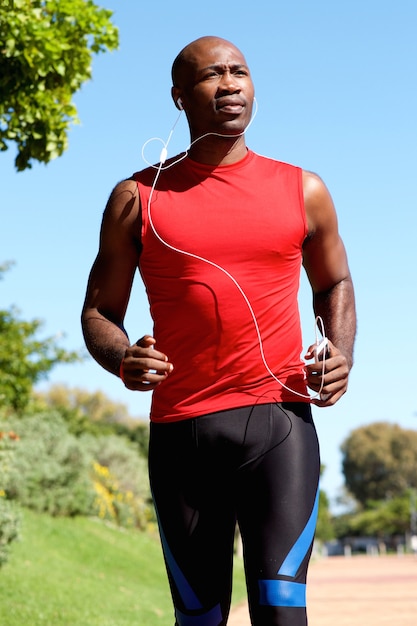 Młody aktywny mężczyzna z hełmofonami jogging outdoors