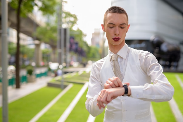 Zdjęcie młody androgyniczny biznesmen sobie szminkę