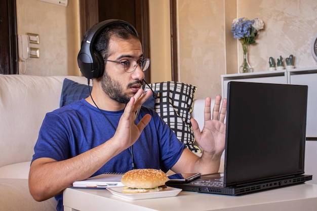 Młody Arab jedzący podczas pracy i w domu