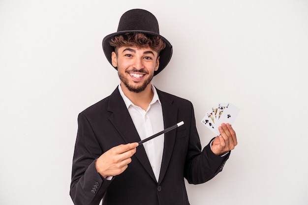 Zdjęcie młody arabski czarodziej mężczyzna trzymający magiczne karty i różdżkę na białym tle