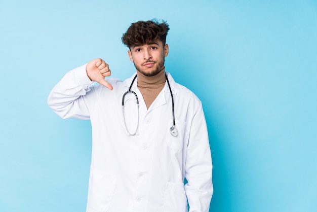 Młody arabski lekarz idolated, pokazując gest niechęci, kciuki w dół. Pojęcie sporu.