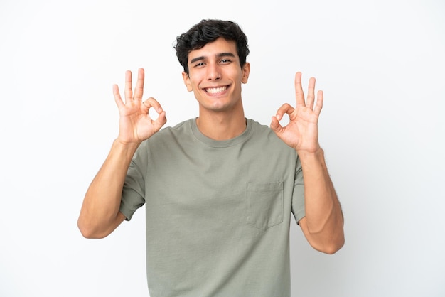 Młody argentyński mężczyzna na białym tle pokazując znak ok dwiema rękami