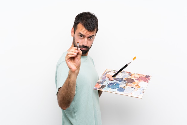 Młody artysty mężczyzna trzyma paletę nad odosobnionym tłem