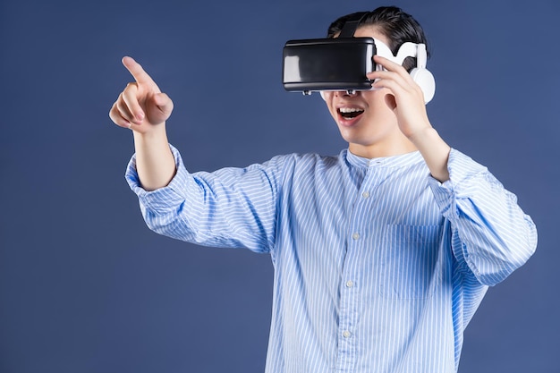 Młody Azjata używający okularów VR na tle