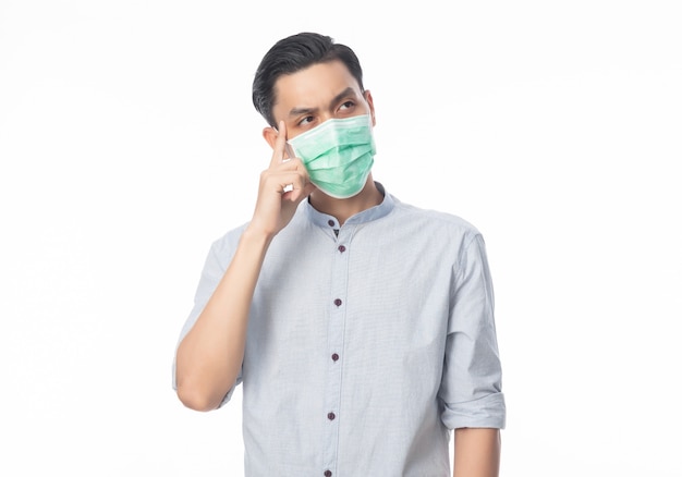Młody Azjatycki biznesmen jest ubranym higieniczną maskę i myśleć, aby zapobiegać infekci, koronawirus. Choroby układu oddechowego przenoszone drogą powietrzną, takie jak walka po południu i grypa na białym tle.