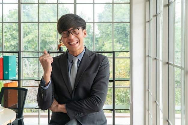 Młody Azjatycki Biznesmen Podekscytowany Szczęśliwy I świętuje Sukces W Miejscu Pracy
