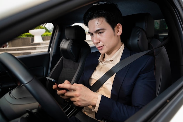 Młody Azjatycki biznesowy mężczyzna z samochodem