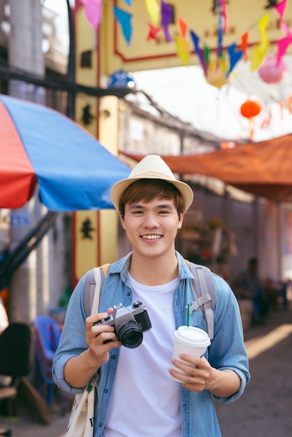 Młody azjatycki człowiek podróżujący zakupy chodzący na targu ulicznym