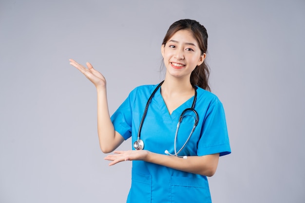 młody azjatycki lekarz kobiet na sobie niebieski mundur na szaro