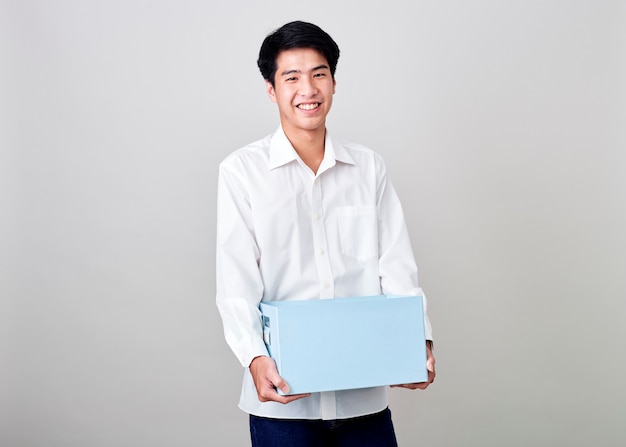 Młody azjatykci biznesmen trzyma pudełko
