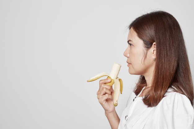Młody azjatykci kobiety mienia banan