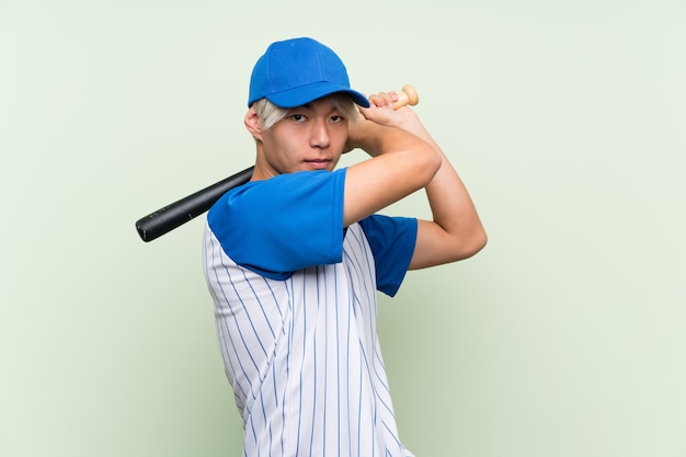 Młody Azjatykci Mężczyzna Bawić Się Baseballa Nad Odosobnionym Zielonym Tłem