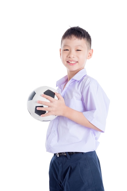 Młody azjatykci uczeń z piłką nad białym tłem
