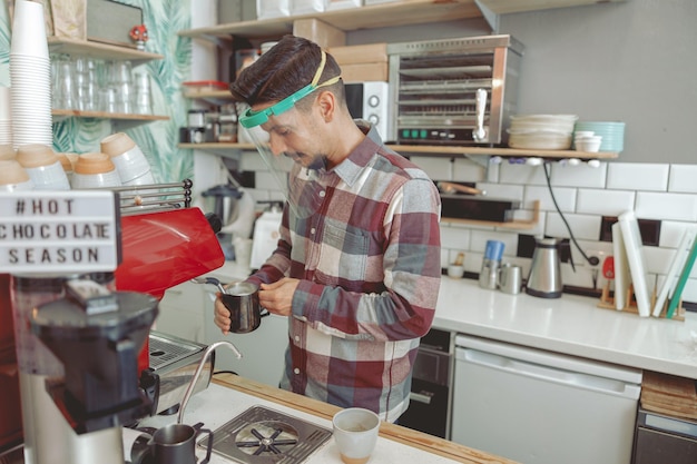 Młody Barista Spieniający Mleko W Ekspresie Do Kawy