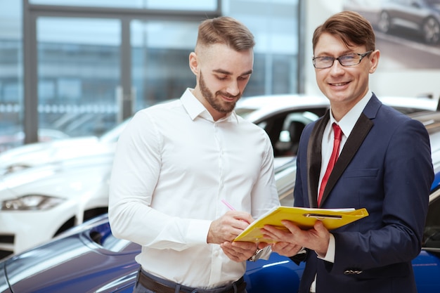 Młody biznesmen kupuje nowy samochód