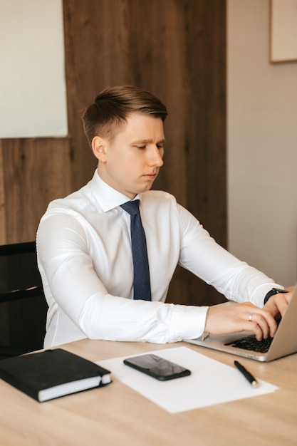 Młody biznesmen mężczyzna pracuje na laptopie w biurze.